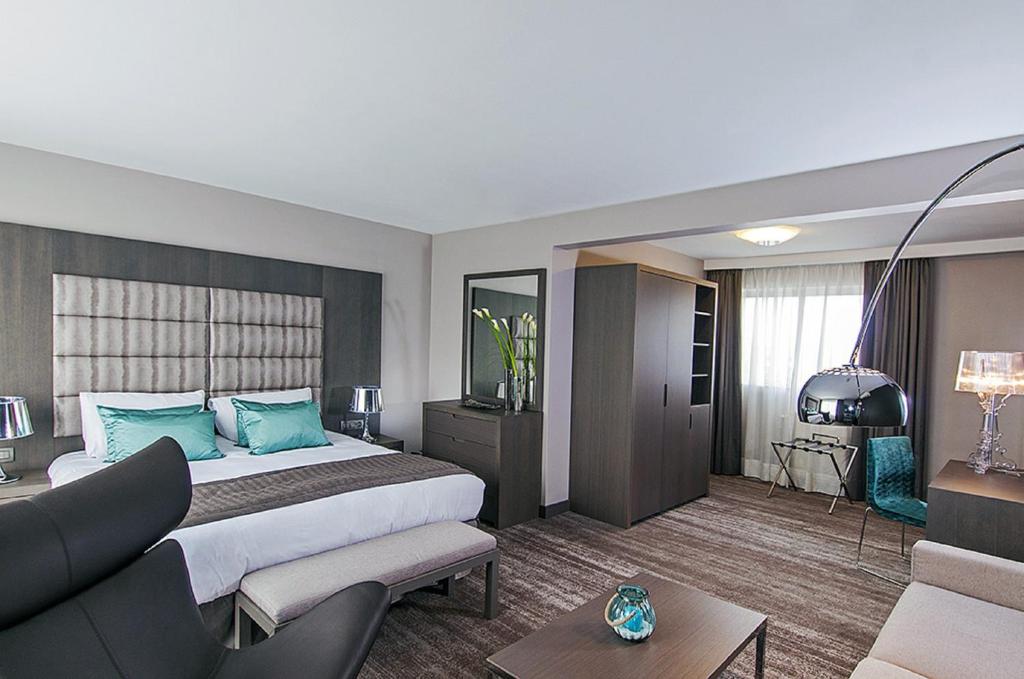 布鲁塞尔阿根达路易丝酒店的酒店客房设有一张大床和一张沙发。