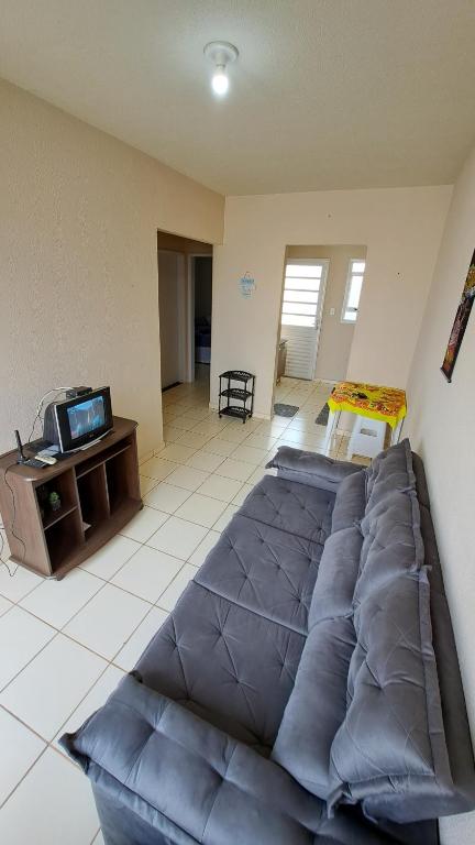 马里利亚Casa Confortável Mobiliada的一间配有电视的客房内的一张蓝色大床