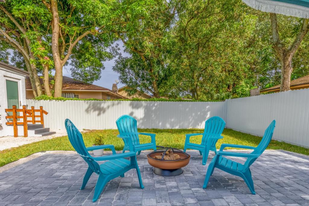 迈阿密Serenity Lodge Condo的院子里有四把蓝色椅子和一个消防栓