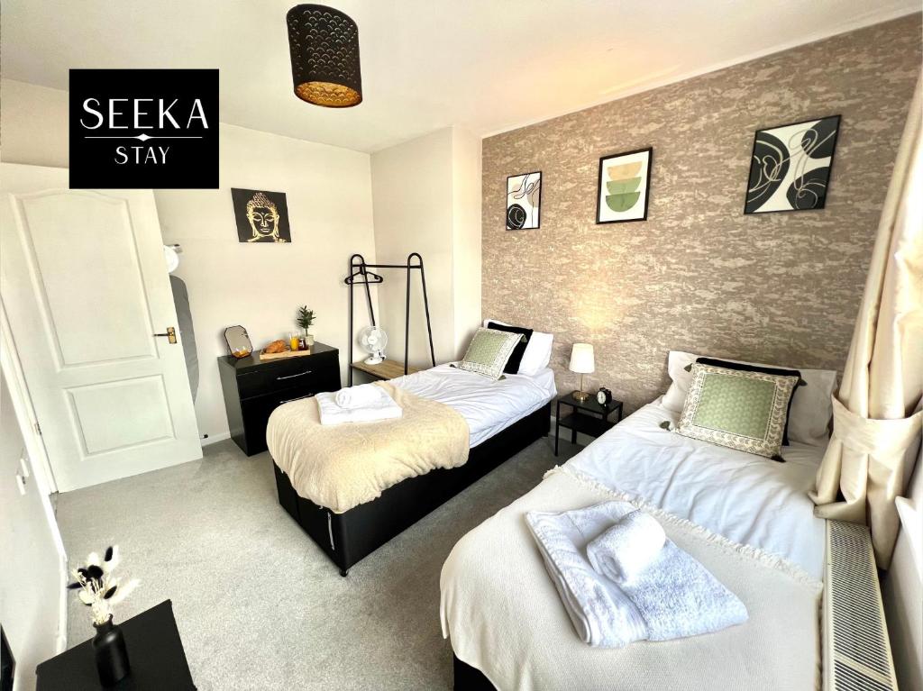 考文垂Greenwood的一间卧室设有两张床和一个阅读Sekka住宿的标志。
