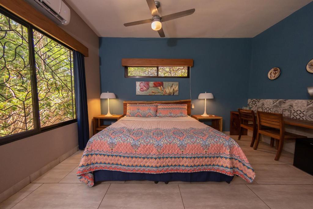 AltagraciaXalli Beach Hotel的一间卧室配有一张蓝色墙壁和窗户的床
