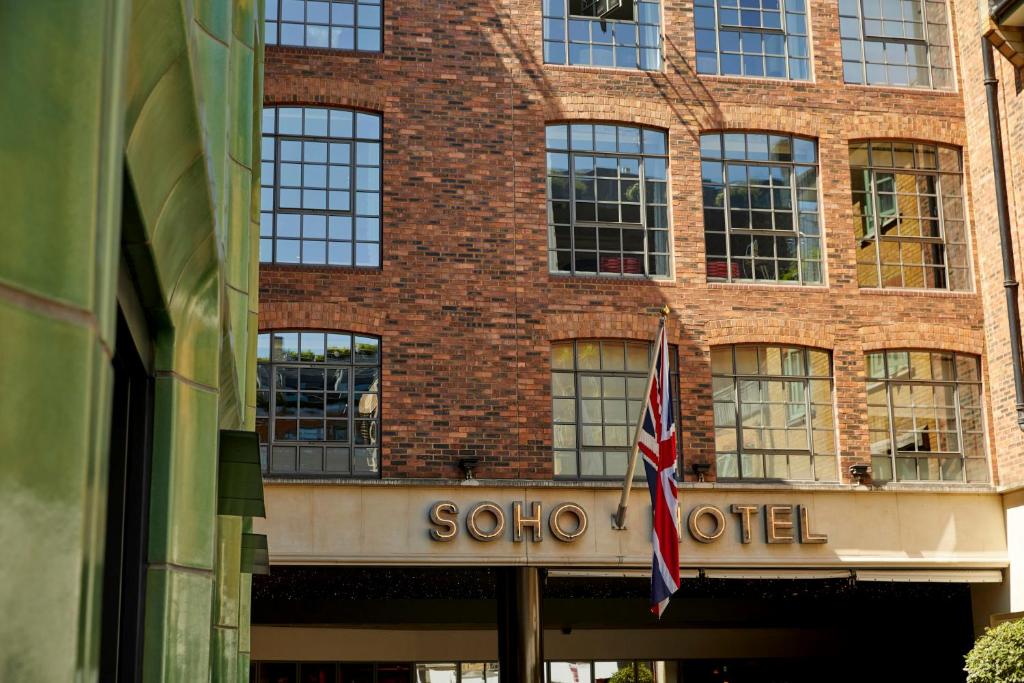 伦敦索霍菲尔姆戴尔酒店的红砖建筑,带有凉爽的标志和旗帜