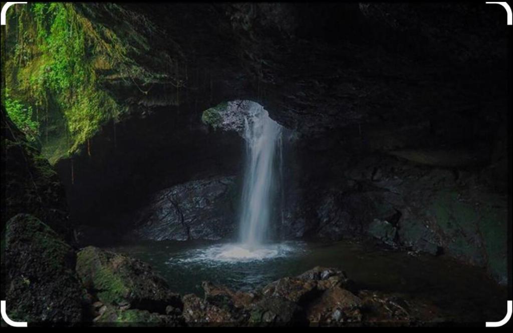 贾丁Cabaña y temazcal Mastai的洞穴中的一个瀑布