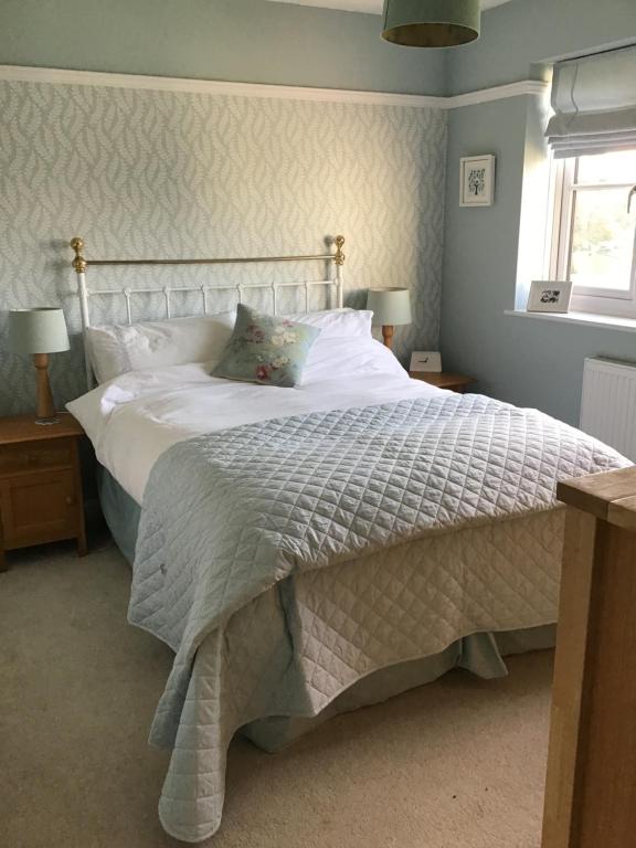 布里斯托A place to stay in Stoke Gifford的卧室配有一张带白色床单的大床和窗户。