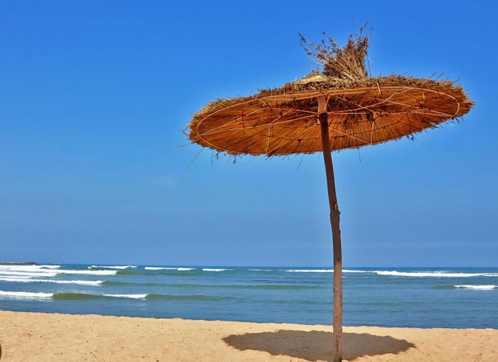 布兹尼盖Apparemment de luxe Bouznika的海滩上的草伞和海洋