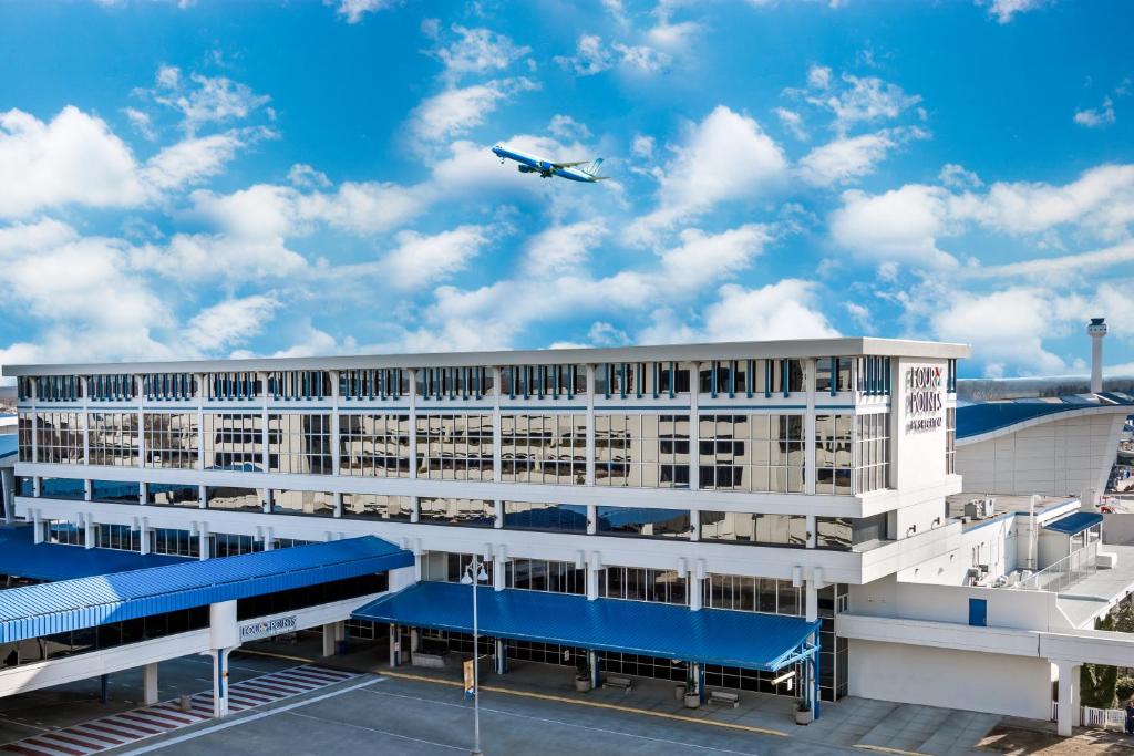 麦迪逊福朋亨茨维尔机场酒店的飞机飞越有机场的大楼