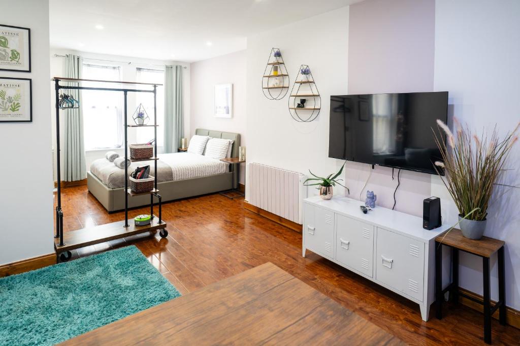 伯恩茅斯REEF7 - Modern central flat, 5 mins from beach, centre and Bournemouth International Centre的一间带电视和沙发的客厅