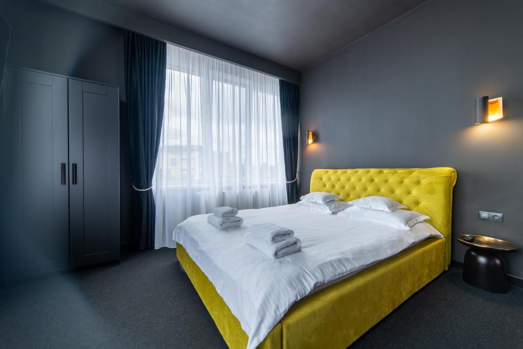 克卢日-纳波卡泽罗旅馆的一间卧室设有黄色的床和窗户。