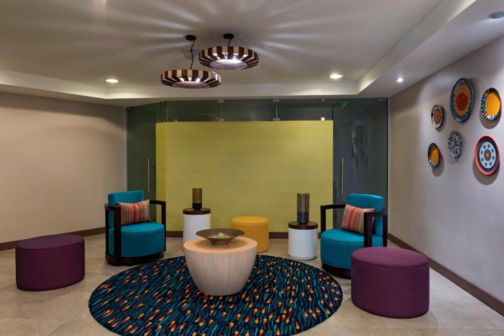 圣萨尔瓦多圣萨尔瓦多万豪费尔菲尔德酒店 的一间设有五颜六色椅子和桌子的等候室