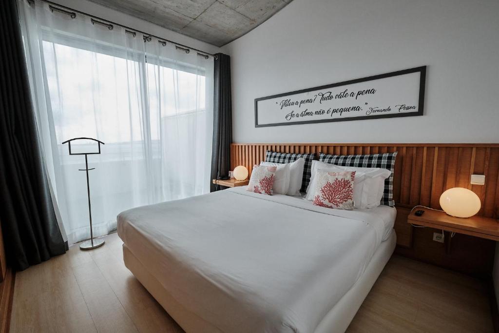 普拉亚达维多利亚Hotel Praia Marina by RIDAN Hotels的卧室设有一张白色大床和一扇窗户。