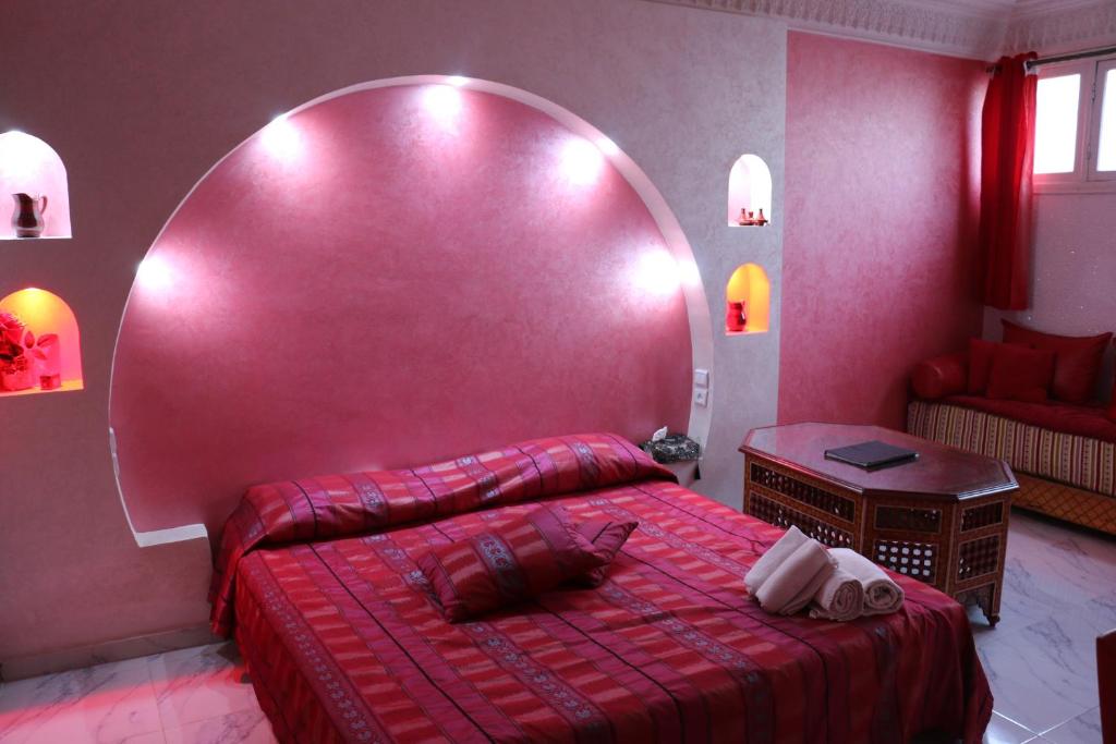 阿加迪尔里亚德乐斯克缇斯达佳迪尔酒店的一间卧室配有一张红色大床和大镜子