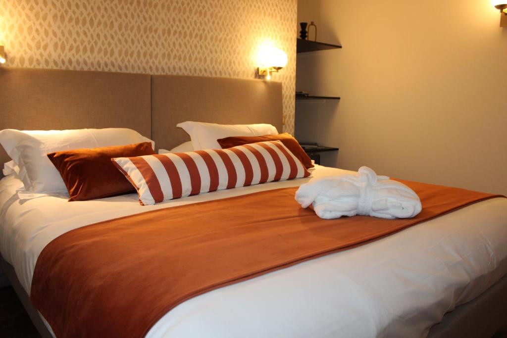 布里夫拉盖亚尔德Hôtel La Truffe Noire的一间卧室配有一张大床和毛巾