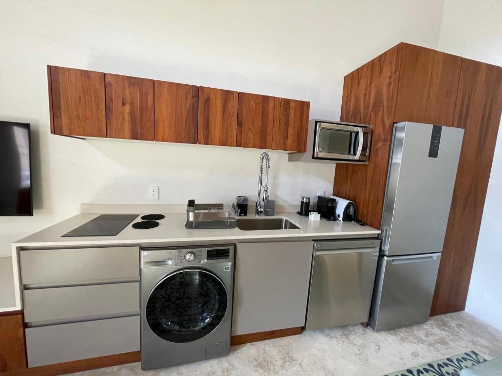 坎佩切Las Lupitas Hotel Boutique的厨房配有洗衣机、水槽和冰箱。