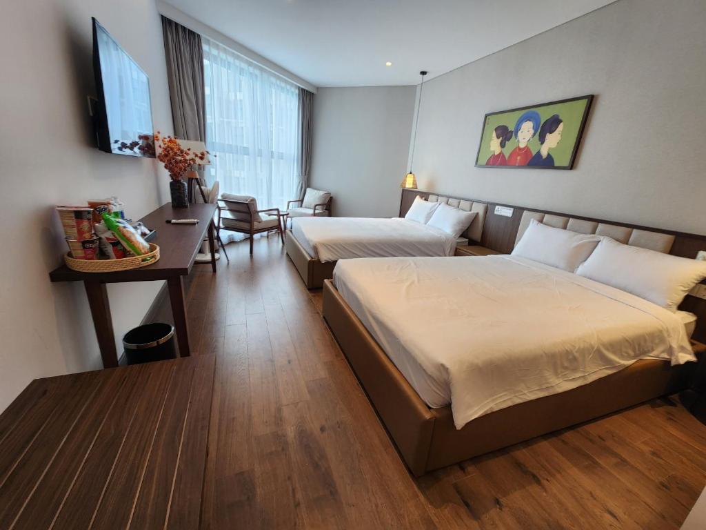 Ấp Thiẹn ÁiApec Mandala Wyndham Mui Ne - V Ruby的酒店客房配有两张床和一张书桌