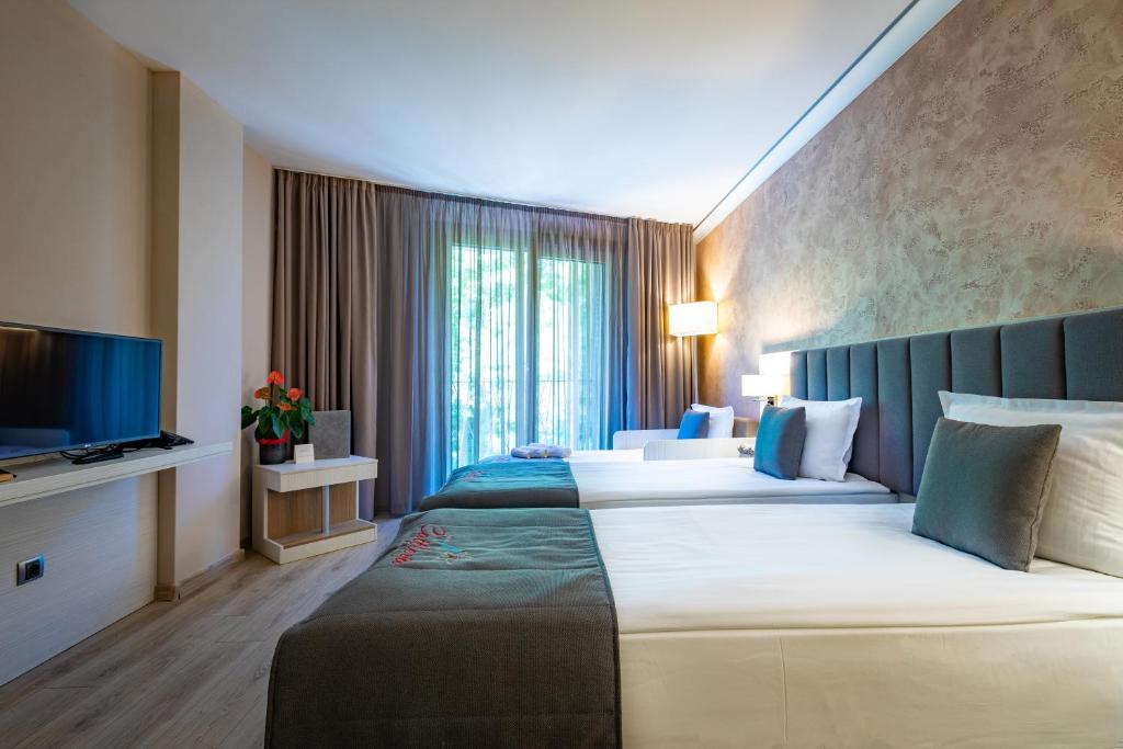 克鲁舒纳Hotel & Relax Zone Cattleya的酒店客房设有两张床和电视。
