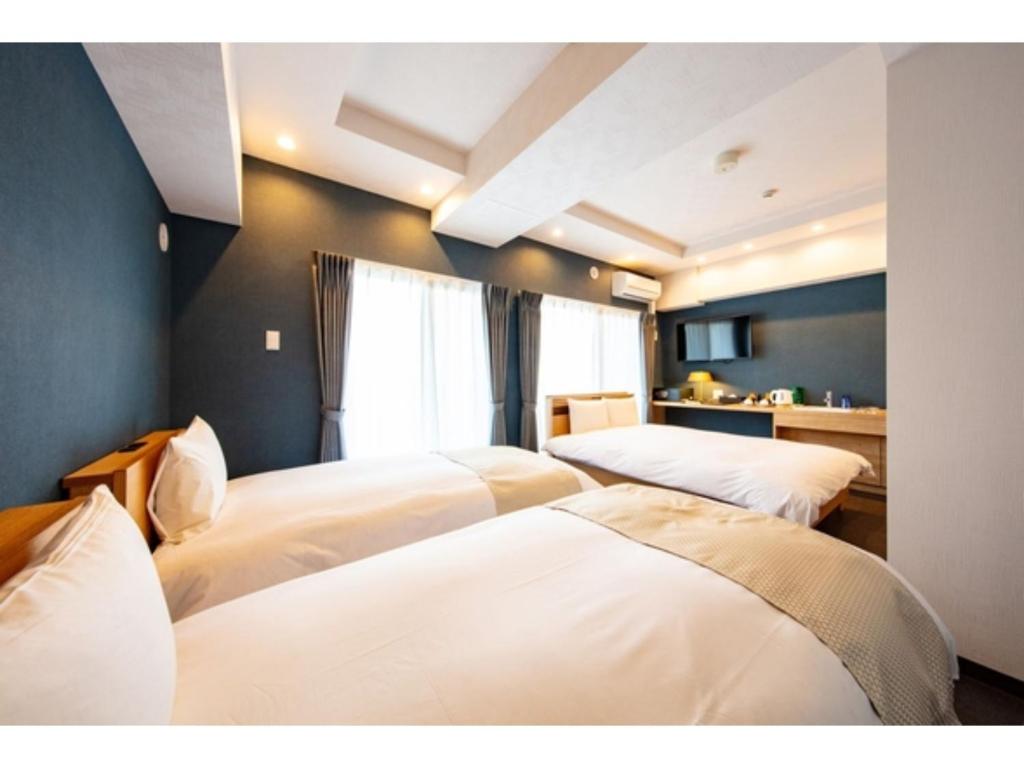札幌VILLA KOSHIDO KOTONI - Vacation STAY 49614v的一间卧室,配有三张床
