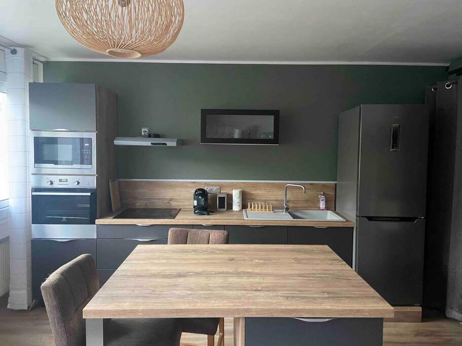 尚贝里Studio de 28 m2 lumineux et élégant的厨房配有木桌和冰箱。