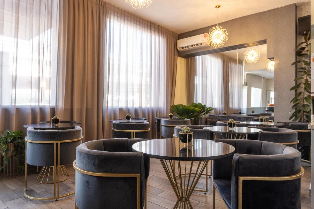 蒙特雷Hotel Boutique de Firma的一间带桌椅和窗帘的餐厅