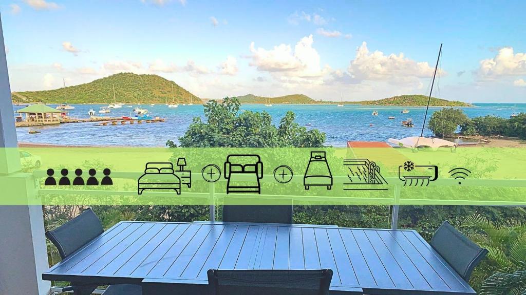 Cul de SacLe Martini-Vue MER et PINEL terrasse piscine的阳台配有桌子,享有海滩美景