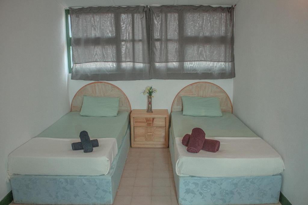 BeironaVila Paradise Sea & Swimming Pool View的两张床位于带十字架的房间