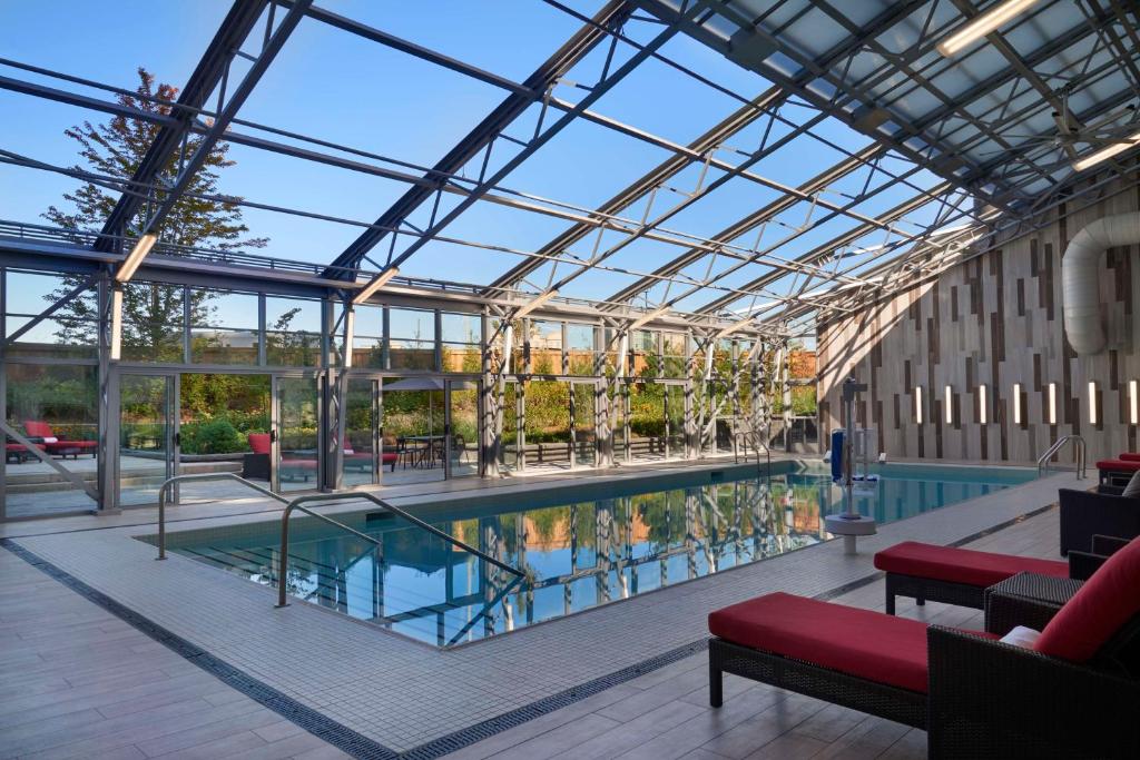 米西索加多伦多机场希尔顿酒店的一座带玻璃天花板的建筑中的游泳池