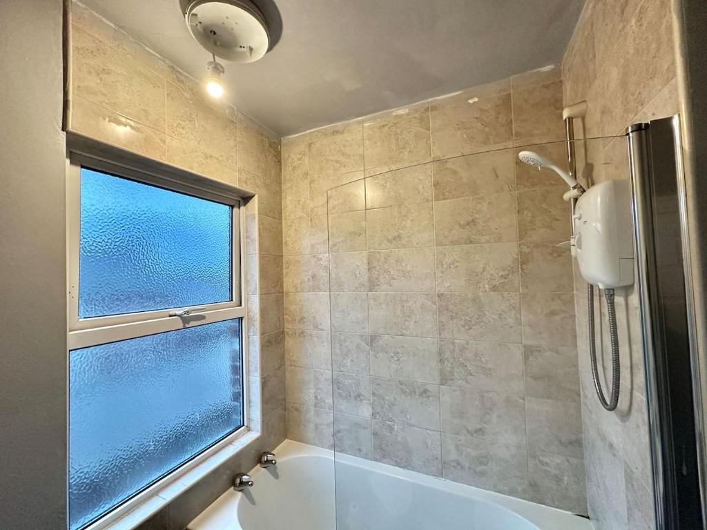 巴恩斯利Perfect Group/Contractors Home的带浴缸和窗户的浴室