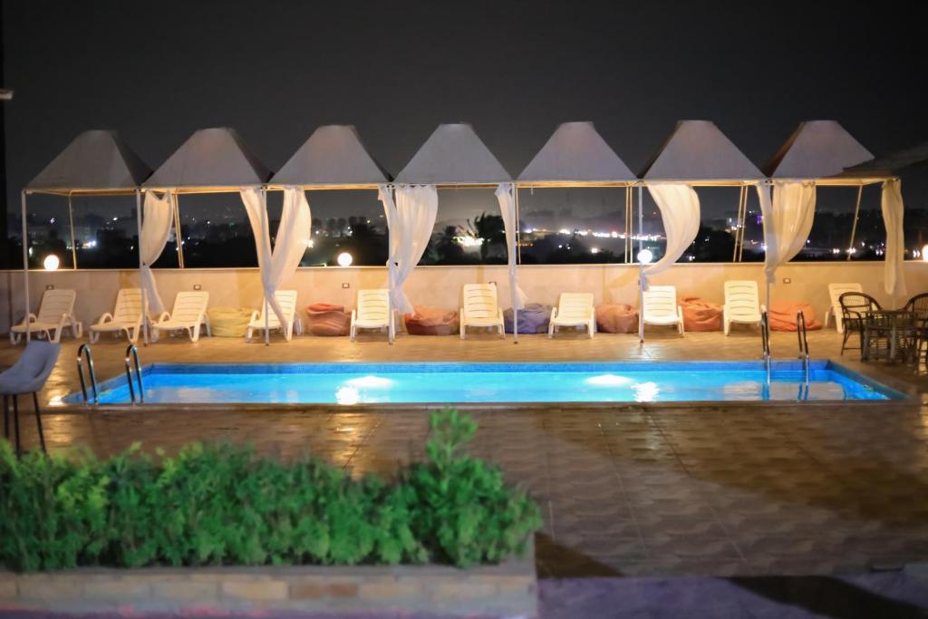 开罗Horus Mini Resort的一个带游泳池和椅子的度假胜地和一座建筑