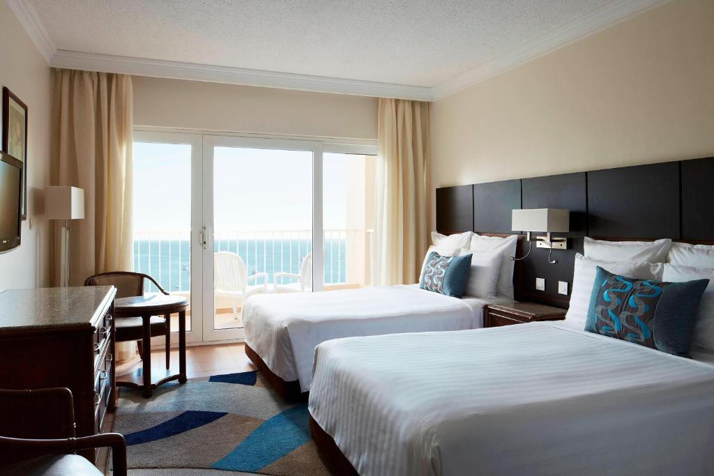 赫尔格达Hurghada Marriott Beach Resort的酒店客房设有两张床和大窗户。