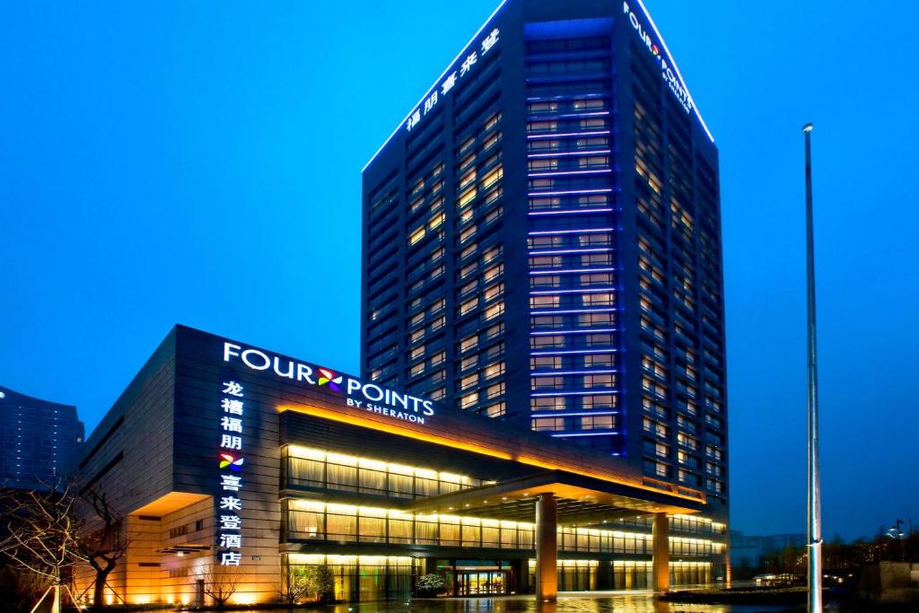杭州杭州龙禧福朋喜来登酒店的一座高大的建筑,上面有四个标志