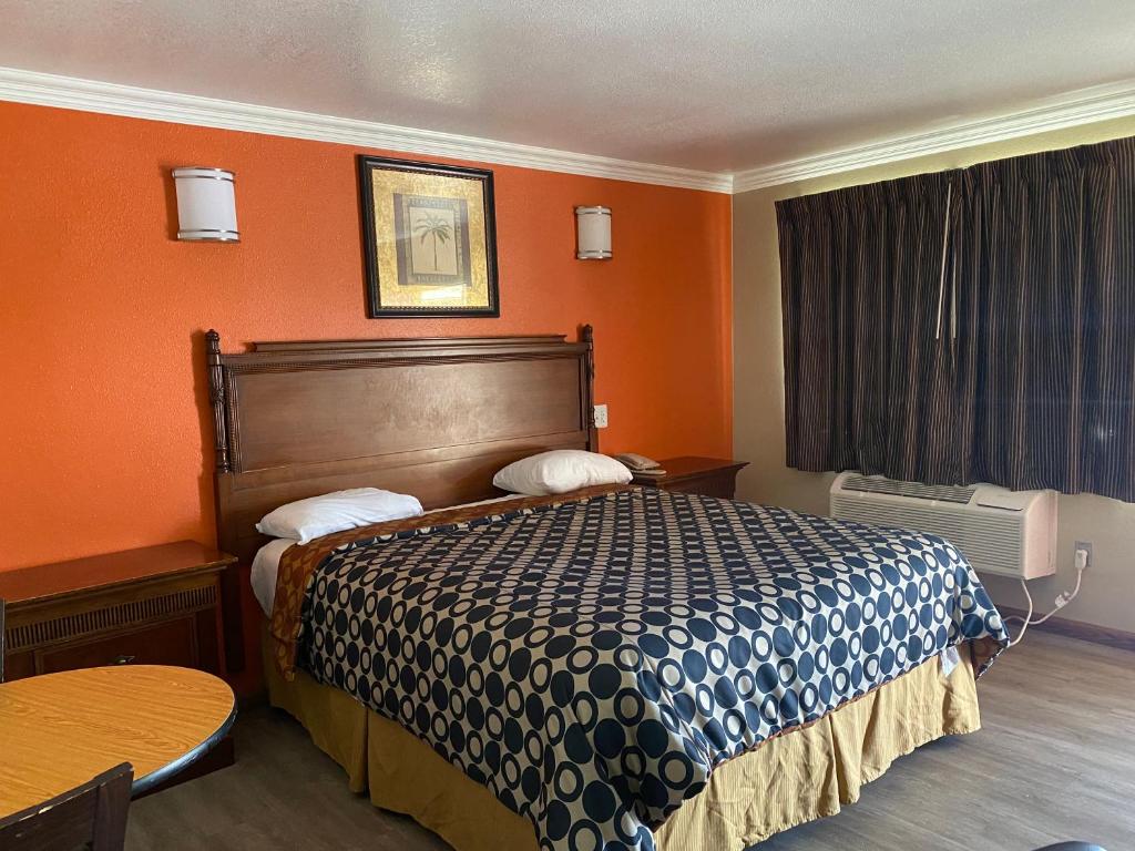 圣贝纳迪诺市中心7号汽车旅馆的酒店客房,配有一张橙色墙壁的床