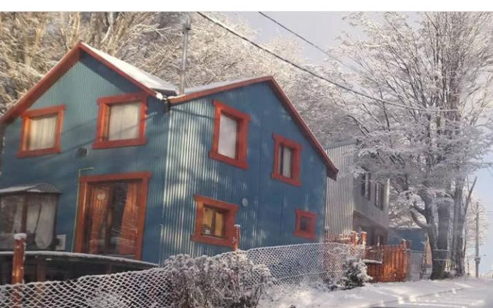 乌斯怀亚Dream Landscape的雪中带红色窗户的蓝色房子