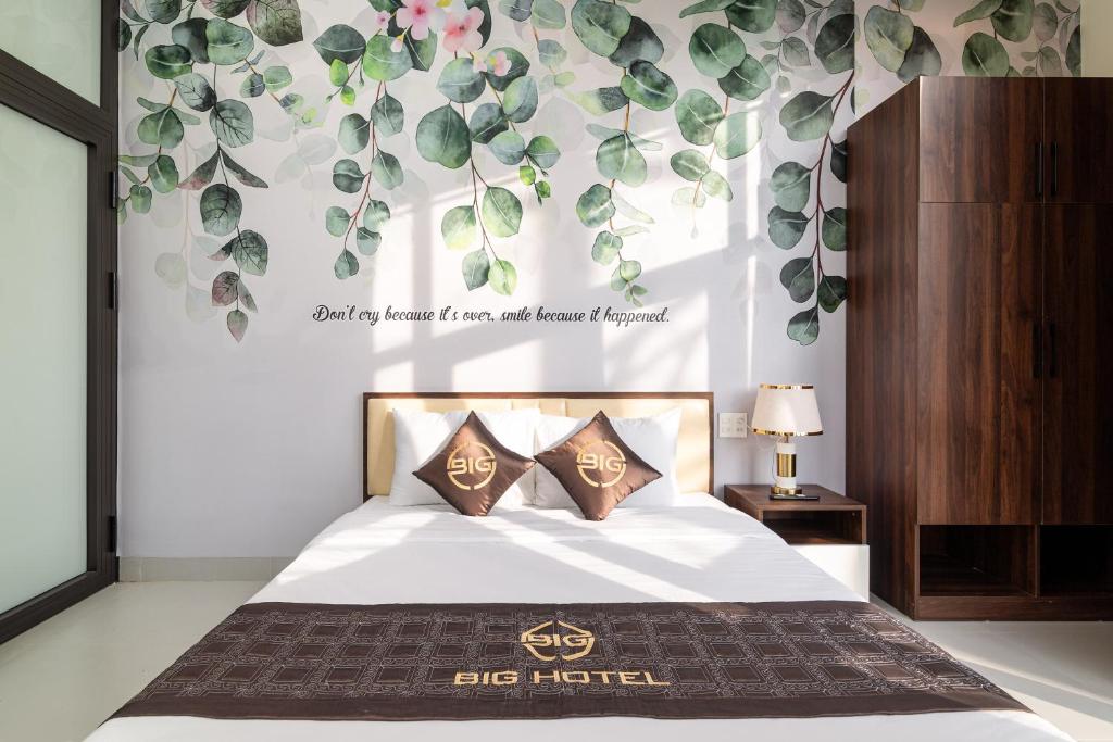 顺化BIG Hotel Huế的卧室配有一张挂有墙上标志的床