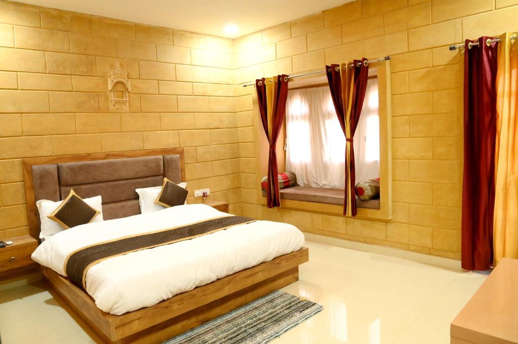 斋沙默尔The Travel Bug Jaisalmer的一间卧室配有一张大床和镜子
