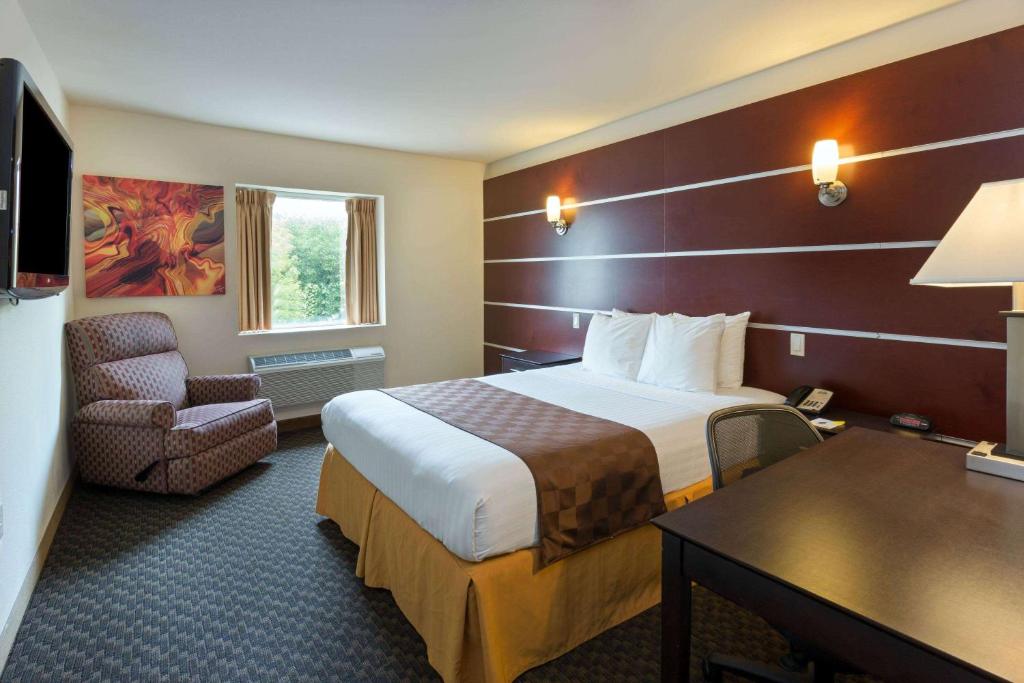密尔沃基戴斯艺术套房酒店的酒店客房带一张大床和一把椅子