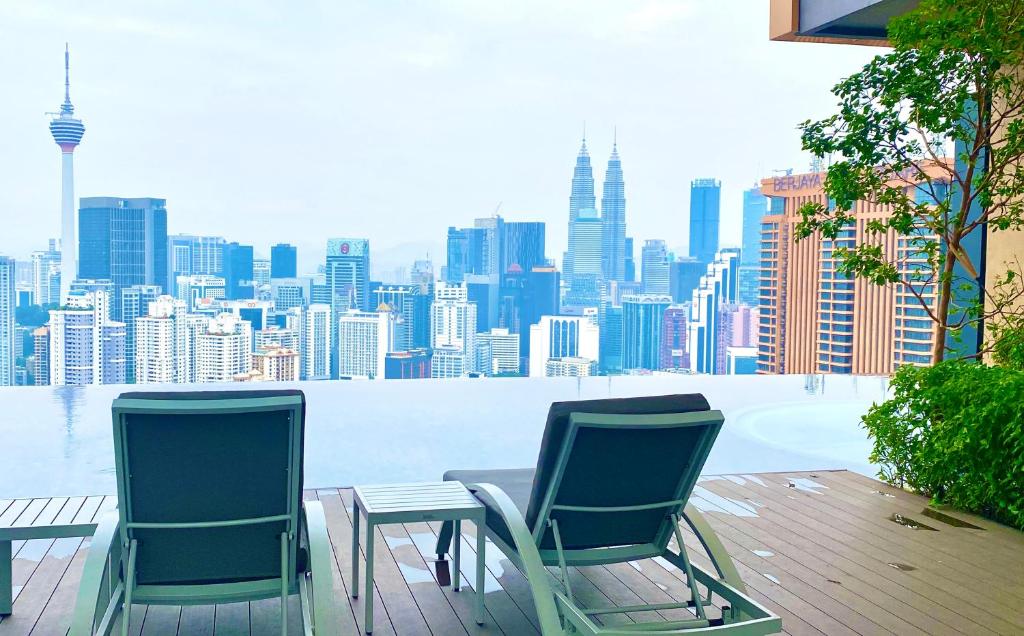 吉隆坡Lalaport Suites At Lucentia Bukit Bintang City Center的两把椅子和一张桌子,享有城市美景