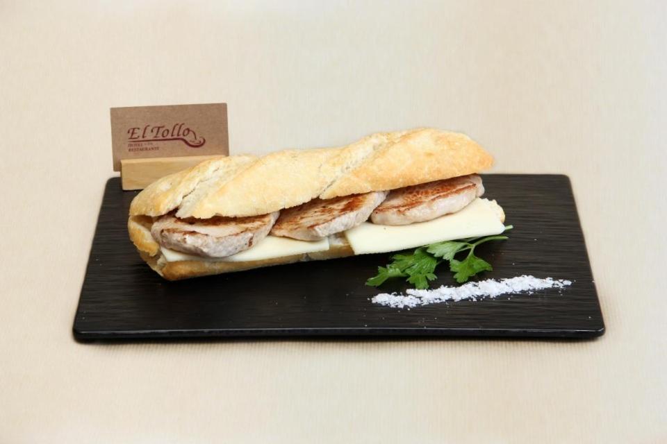 巴塞罗那"Casa TOLIMA"的黑盘上的三明治,包括肉类和奶酪