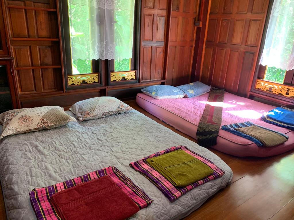 Ban Khu Ha Nai (1)โฮมสเตย์บ้านนายสิงโตเขาคูหา的带2扇窗户的客房内的2张床