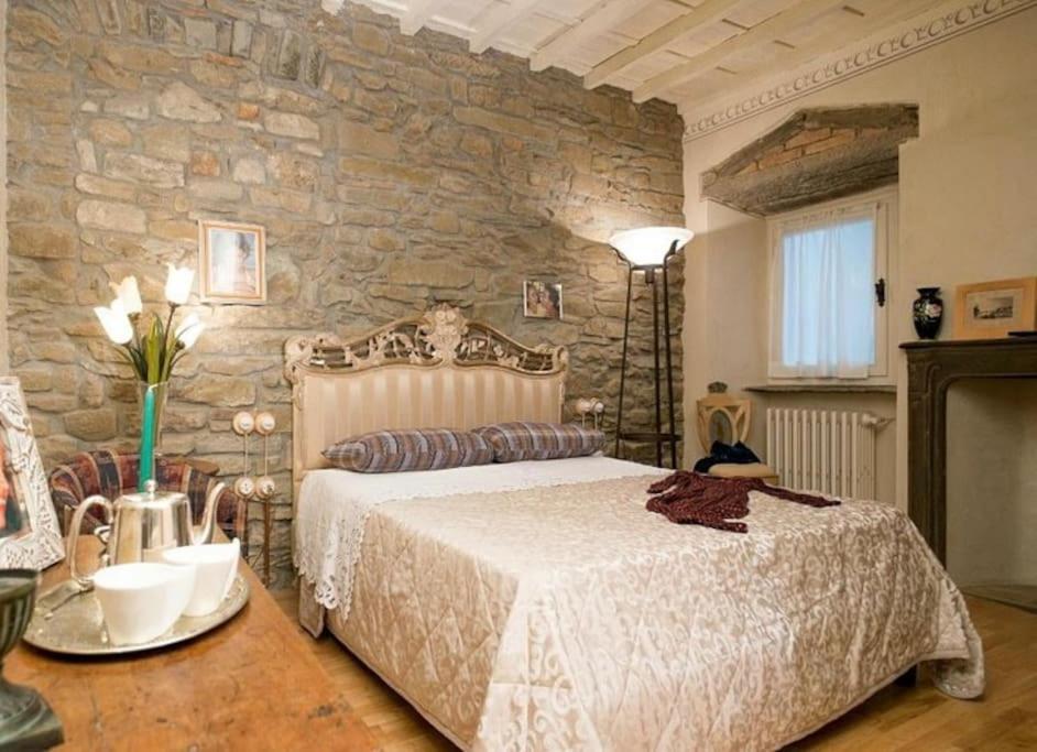 菲耶索莱Casa Sofia的一间卧室设有一张床和石墙