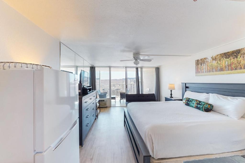 檀香山Island Colony 3715的卧室配有白色的床和冰箱。