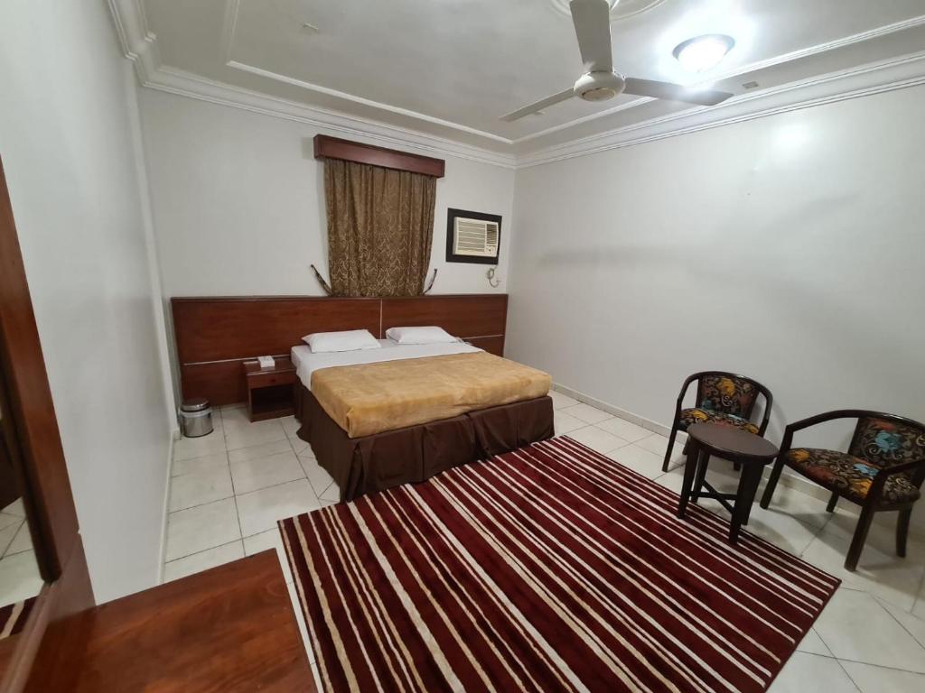 麦加شقق درة الصالحين的一间卧室配有一张床,里面铺有红色地毯
