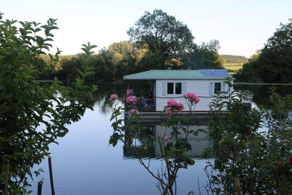 圣让德洛讷Cottage flottant Saint Jean de Losne option jacuzzi的水面上的房子,花朵
