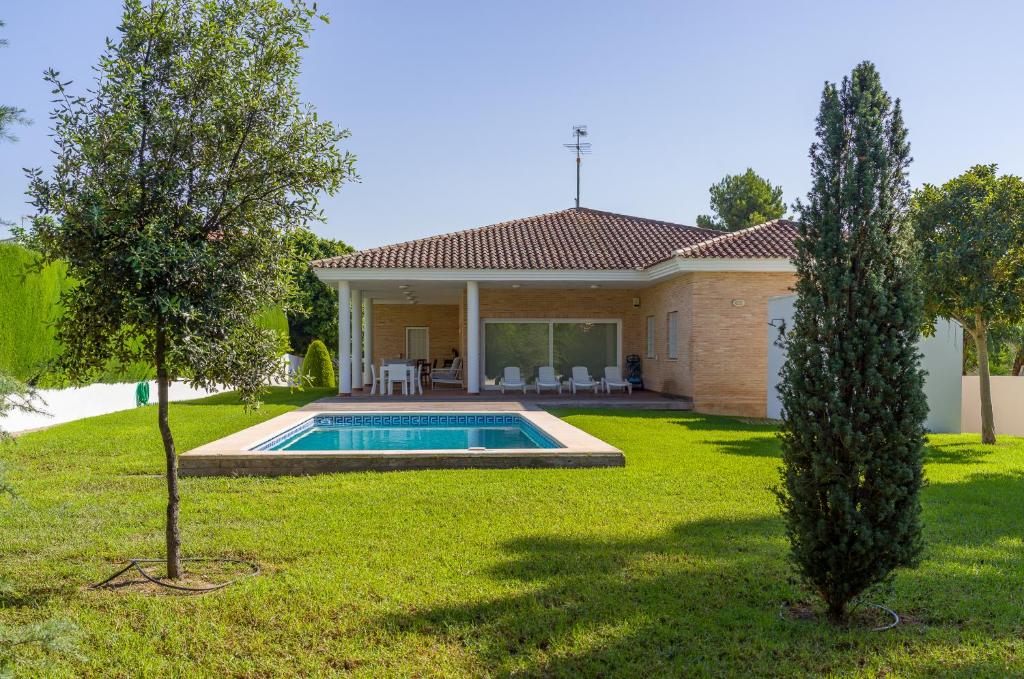 瓦伦西亚Villa con piscina, jardín y aire acondicionado en La Eliana-L'Eliana的庭院中带游泳池的房子