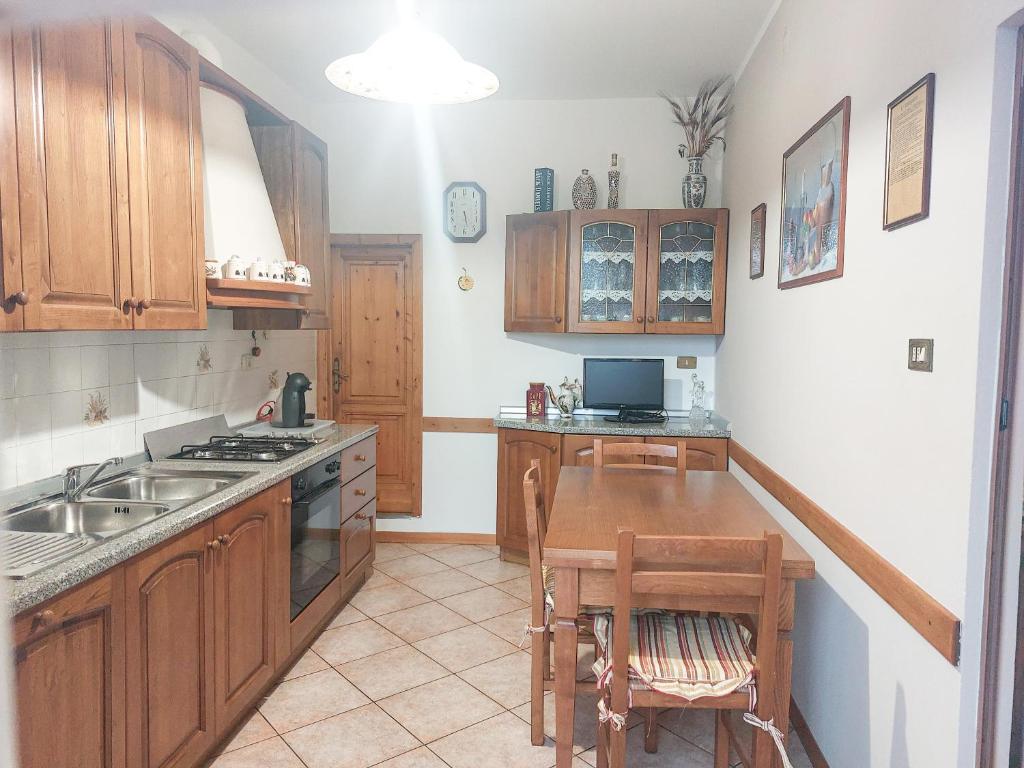 皮斯托亚Pistoia ROSE Appartamento的厨房配有木制橱柜和木桌。