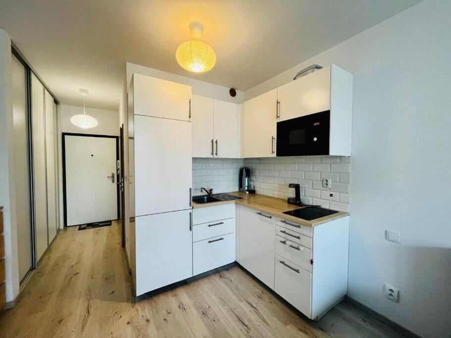 布拉迪斯拉发Apartmán v Bratislave的厨房铺有木地板,配有白色橱柜。