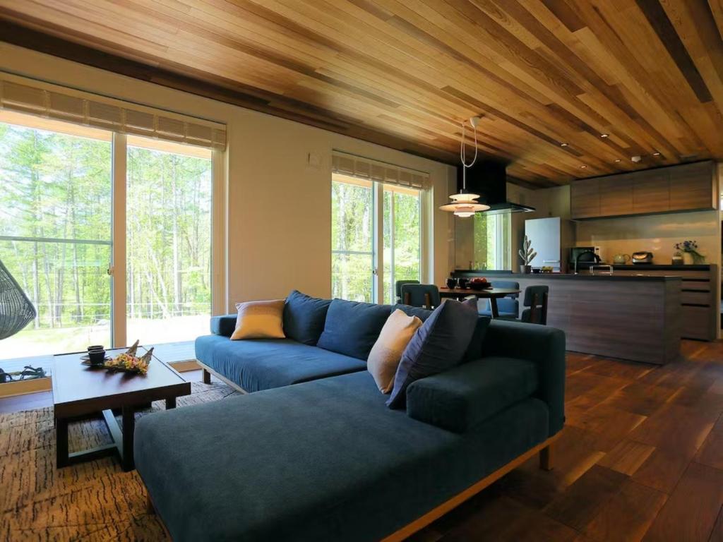 茅野Class Vesso Tateshina - Vacation STAY 51980v的一间带蓝色沙发的客厅和一间厨房