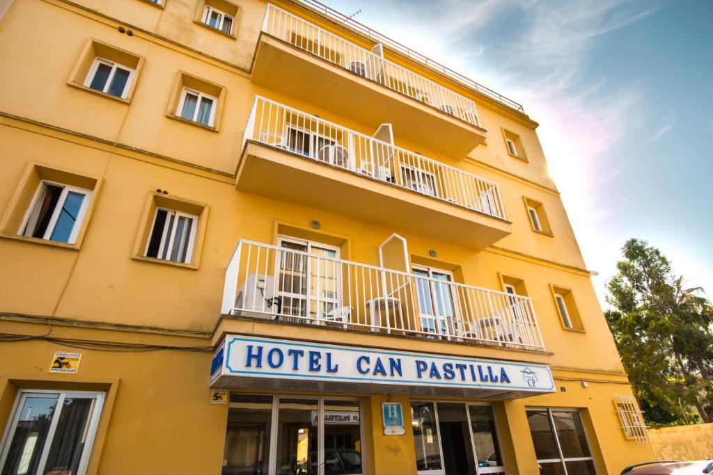 坎帕斯蒂利亚肯斯蒂利亚爱米克酒店的黄色的建筑,上面有酒店的canatu标志