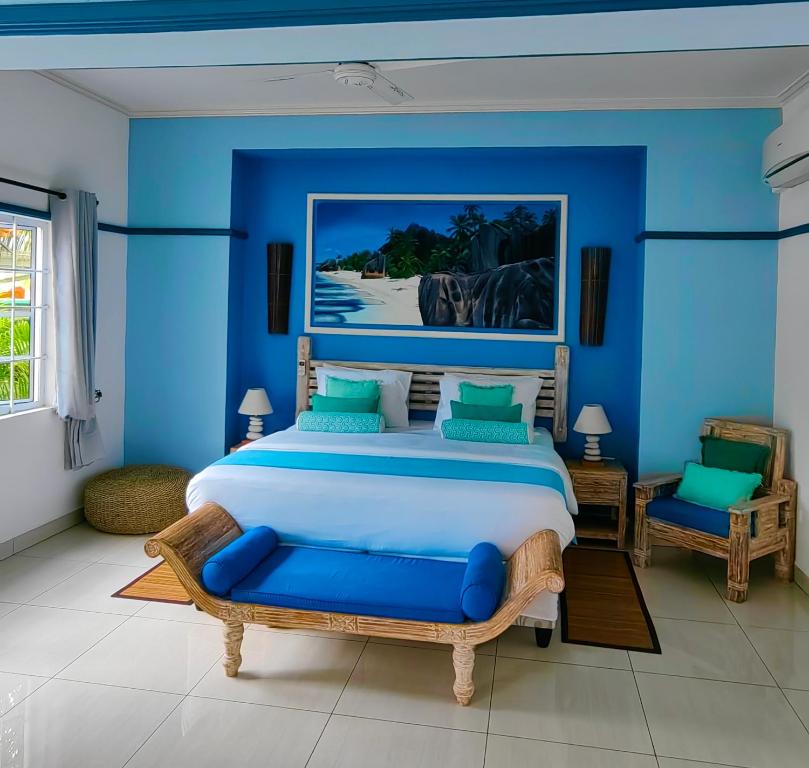 留尼汪海岛魅力别墅的一间卧室设有一张大床和蓝色的墙壁