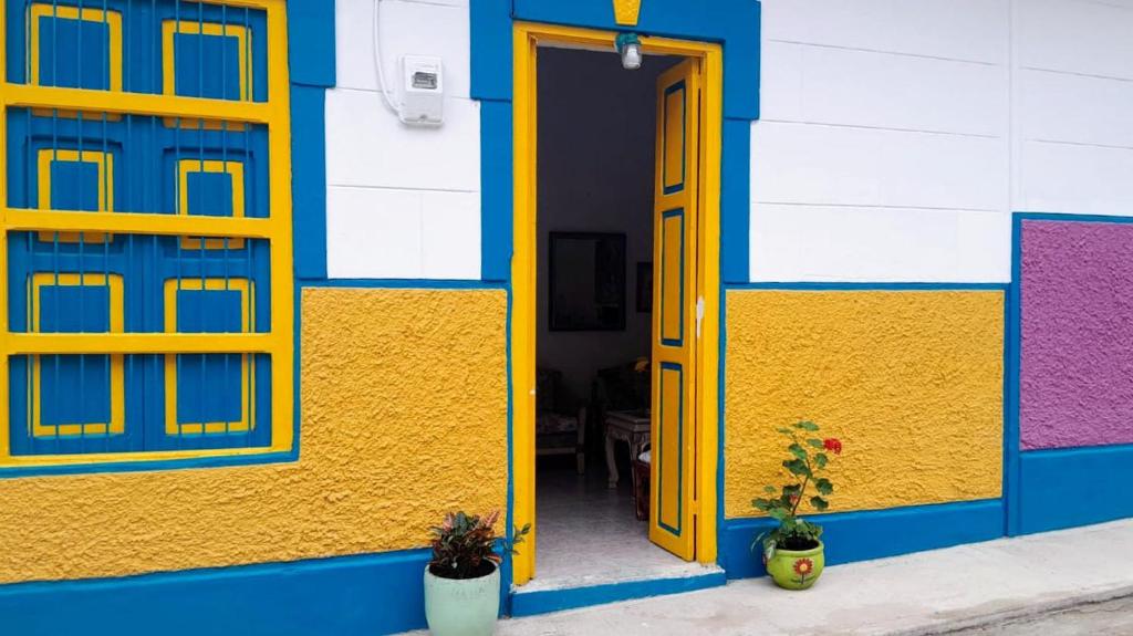 麦德林Casa de huéspedes la Casona.的黄色的建筑,设有黄色的门和窗户