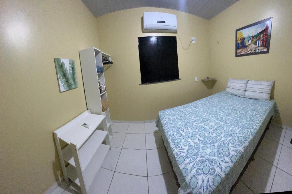 新艾朗Casa Boto Tucuxi 2的一间带床和冰箱的小卧室