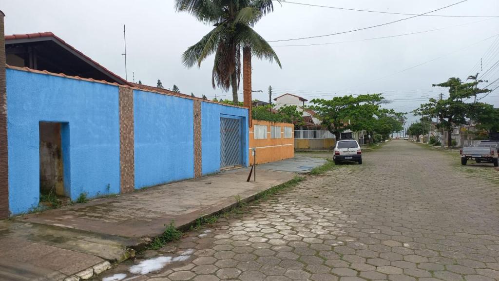 佩鲁伊比Peruíbe casa 150 metros praia 3 dormitórios casa independente的街道边的蓝色建筑